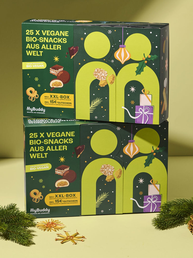 myBuddy Adventskalender 2026, BIO-VEGAN, zwei Verpackungen gestapelt, beiger Hintergrund