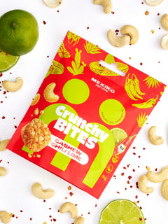 myBuddy Crunchy Nut Bites Cashew Chili Lime aus dem 9er-Set, einzelner 30-g-Beutel im Flatlay mit Limette, Cashewkernen und Chiliflocken
