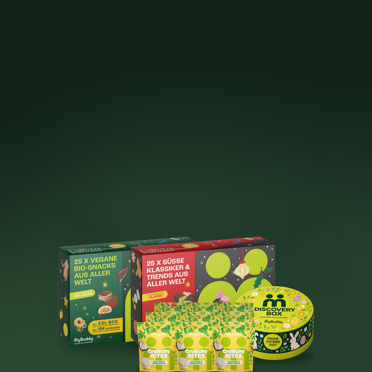 myBuddy HAVE IT ALL Starterpaket, Adventskalender CLASSIC und BIO-VEGAN, Crunchy Nut Bites Coconut Pineapple und Discovery Box Ostern Edition vor dunkelgruenem Hintergrund