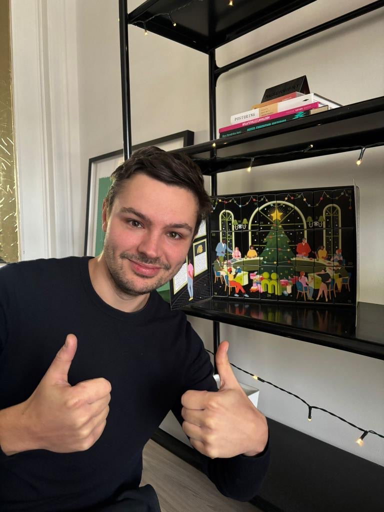 myBuddy Community-Foto: Mann mit zwei Daumen hoch vor dem aufgestellten, aufgeklappten Kalender im Regal