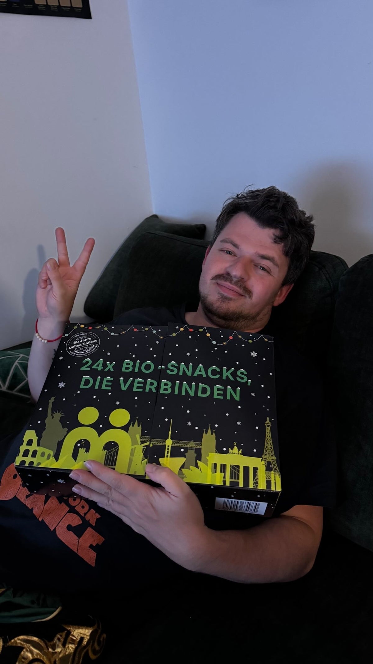 myBuddy Community-Foto: Mann liegt auf grünem Sofa, Peace-Zeichen, Kalender auf dem Bauch