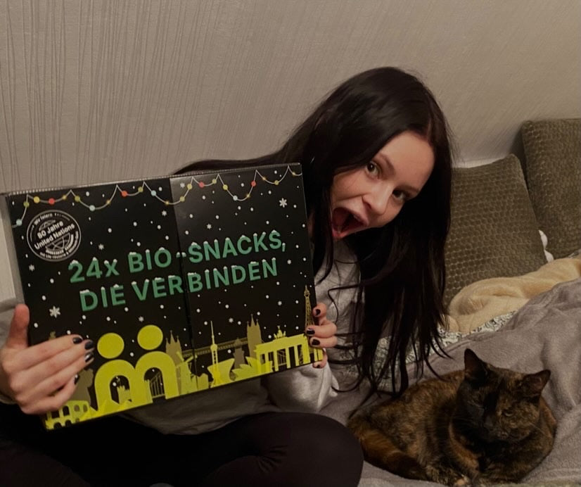 myBuddy Community-Foto: Dunkelhaarige Frau reißt auf dem Bett den Mund auf, Kalender vor sich, Schildpattkatze daneben